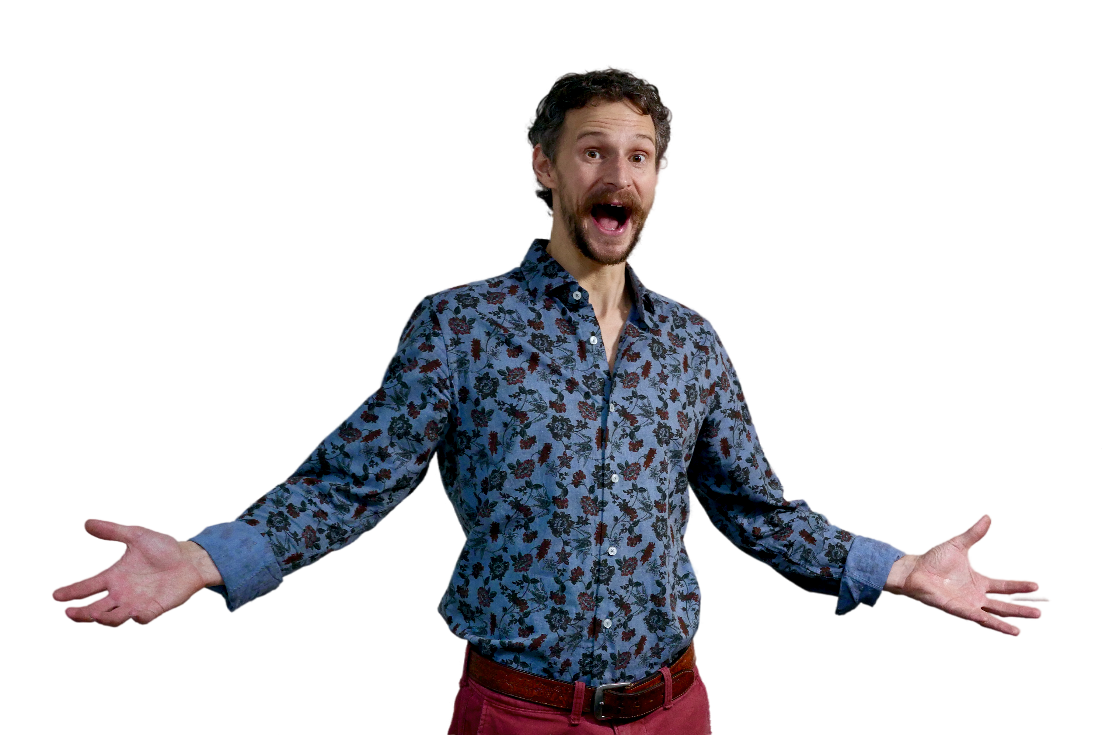 Dan smiling and holding his arms open in an excited, welcoming way. Wearing a blue button-up shirt.